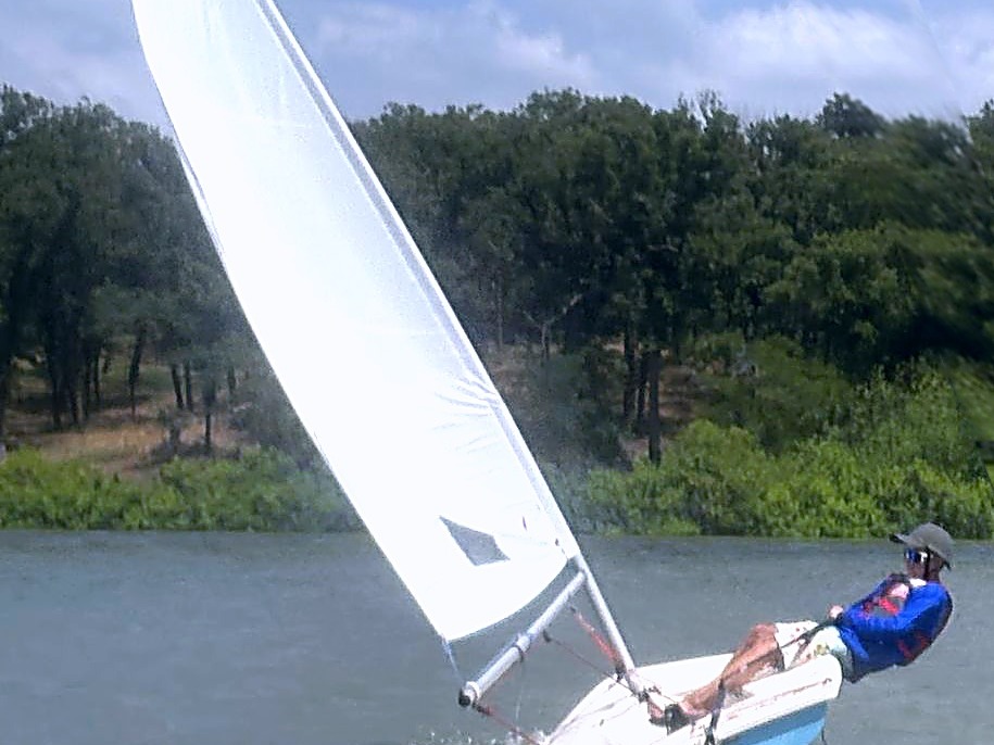 A young DCYC sailor hikes out under sail